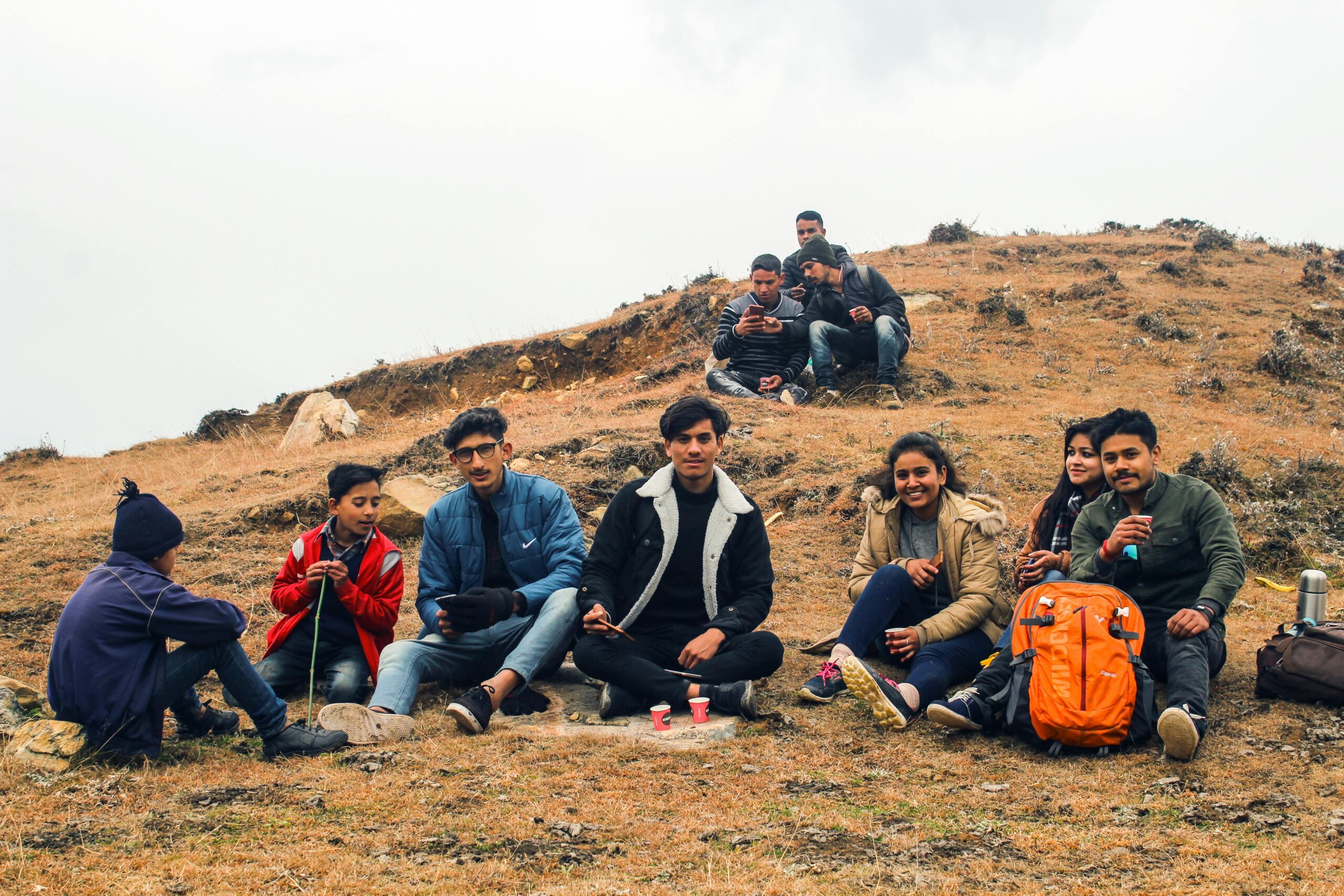 A group of friends relaxing on a scenic hilltop in Malkhi, India, enjoying nature.